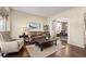 Cozy living room with plush seating and elegant archway to dining room at 5128 Longs Peak St, Brighton, CO 80601