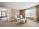 Cozy sitting room featuring neutral tones, natural light, comfortable chairs, and soft ottomans at 5128 Longs Peak St, Brighton, CO 80601