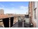 Balcony with black railings, wicker furniture, and amazing views of the city skyline at 1301 Wazee St # 3C, Denver, CO 80204
