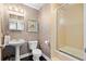 Bathroom with pedestal sink, framed mirror, tiled shower with glass doors, and modern finishes at 1301 Wazee St # 3C, Denver, CO 80204