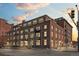 Low angle, exterior elevation of brick apartment building on a city street at dusk at 1301 Wazee St # 3C, Denver, CO 80204