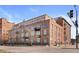 The Academy, an elegant brick building with large windows and sleek black iron balconies under a beautiful blue sky at 1301 Wazee St # 3C, Denver, CO 80204