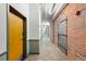 Apartment hallway with painted walls, brick accents, and industrial lighting at 1301 Wazee St # 3C, Denver, CO 80204