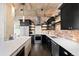Modern kitchen with stainless steel appliances, white countertops, dark cabinetry, and brick backsplash at 1301 Wazee St # 3C, Denver, CO 80204