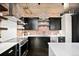 Modern kitchen features stainless steel appliances, brick backsplash, and dark cabinetry at 1301 Wazee St # 3C, Denver, CO 80204