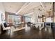 An open floor plan features a kitchen, dining and living area with exposed ceiling, brick accent wall and large windows at 1301 Wazee St # 3C, Denver, CO 80204