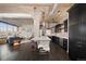 A view of the modern open floor plan with stainless appliances, a white kitchen island, and exposed ductwork and brick at 1301 Wazee St # 3C, Denver, CO 80204