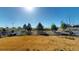Large backyard with a partial white wood fence offers privacy and views of a community park in the distance at 3062 Grizzly Peak Dr, Broomfield, CO 80023
