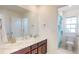 Bathroom featuring double sinks, modern fixtures, and a peek into the shower area at 3062 Grizzly Peak Dr, Broomfield, CO 80023
