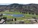 High angle view of golf course, a large pond, and homes with a scenic mountain backdrop at 6405 Eagle Feather Trl, Littleton, CO 80125