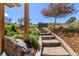 Landscaped backyard with stone steps leading to an outdoor hot tub and seating area at 6405 Eagle Feather Trl, Littleton, CO 80125