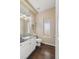 Charming powder room with granite countertop vanity, modern fixtures, and stylish lighting, featuring hardwood floors at 6405 Eagle Feather Trl, Littleton, CO 80125