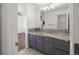 This bathroom showcases a vanity with granite countertops and tile flooring, adjacent to another room at 6405 Eagle Feather Trl, Littleton, CO 80125