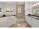 A luxurious bathroom featuring a soaking tub, glass shower, and granite countertops at 6405 Eagle Feather Trl, Littleton, CO 80125