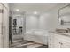 A bright bathroom includes double vanity, soaking tub, granite counters, and wood-look flooring at 6405 Eagle Feather Trl, Littleton, CO 80125