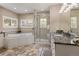 Luxurious bathroom featuring a soaking tub, walk-in shower, granite countertops, and custom cabinetry at 6405 Eagle Feather Trl, Littleton, CO 80125