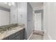 Well-lit bathroom featuring a granite vanity with gray cabinets and modern fixtures, complemented by neutral walls at 6405 Eagle Feather Trl, Littleton, CO 80125