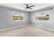 Cozy bedroom with soft carpet, ceiling fan, and bright windows offering scenic neighborhood views at 6405 Eagle Feather Trl, Littleton, CO 80125