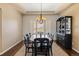 Elegant dining room with a decorative light fixture, a dark wooden table, and a stylish china cabinet at 6405 Eagle Feather Trl, Littleton, CO 80125