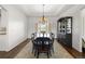 Dining room featuring wood floors, tray ceiling, elegant chandelier and decorative display cabinet at 6405 Eagle Feather Trl, Littleton, CO 80125