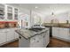 Open kitchen featuring stainless appliances, stone backsplash, granite counters and island with cooktop at 6405 Eagle Feather Trl, Littleton, CO 80125