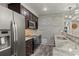 A kitchen with stone backsplash, stainless appliances, granite countertops, and bar seating at 6405 Eagle Feather Trl, Littleton, CO 80125