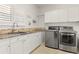 Laundry room features modern washer/dryer, granite counters, sink, and cabinets for efficient storage at 6405 Eagle Feather Trl, Littleton, CO 80125