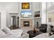 Bright living room features a stone fireplace, a large television, and comfortable seating at 6405 Eagle Feather Trl, Littleton, CO 80125