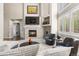 Elegant living room featuring a stone fireplace, vaulted ceilings, and an abundance of natural light at 6405 Eagle Feather Trl, Littleton, CO 80125