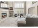 Inviting living room with a stone fireplace, large windows, and a comfortable sectional couch, great for relaxing at 6405 Eagle Feather Trl, Littleton, CO 80125