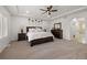Bright primary bedroom features tray ceiling, ceiling fan, and neutral carpet at 6405 Eagle Feather Trl, Littleton, CO 80125