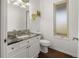 A powder room with a granite vanity and ample lighting at 6405 Eagle Feather Trl, Littleton, CO 80125