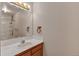 Well-lit bathroom featuring a single sink, wooden vanity, and mirror with decorative lighting at 1225 Baker St, Longmont, CO 80501