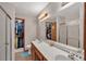 Double sink bathroom vanity with walk-in closet, tile floors, and walk-in shower at 1225 Baker St, Longmont, CO 80501