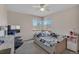 Bright bedroom featuring a ceiling fan, a TV set, and views of the blooming trees outside at 1225 Baker St, Longmont, CO 80501