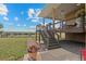 Spacious backyard featuring a covered patio, stairs to the lawn, and landscaping at 11881 County Road 37, Fort Lupton, CO 80621