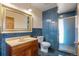 Blue-tiled bathroom features a single vanity and a shower with glass door at 11881 County Road 37, Fort Lupton, CO 80621
