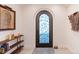 Inviting entryway featuring a unique arched door with decorative glass and white walls at 11881 County Road 37, Fort Lupton, CO 80621