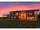 Home exterior at dusk with open porch, stone accents, and outdoor seating at 11881 County Road 37, Fort Lupton, CO 80621
