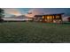 Expansive exterior view of home with large lawn and a colorful sunset in the background at 11881 County Road 37, Fort Lupton, CO 80621