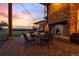Charming outdoor patio with a stone fireplace, perfect for evening relaxation and entertaining at 11881 County Road 37, Fort Lupton, CO 80621
