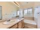 Bathroom featuring double sinks and a tub with a window at 371 Granby Way # C, Aurora, CO 80011