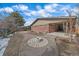 Exterior view of a backyard with a stone fire pit, patio, and landscaping at 6630 E Virginia Ave, Denver, CO 80224