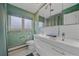 Stylish bathroom with modern vanity, dual sinks, and unique wallpaper design at 6630 E Virginia Ave, Denver, CO 80224