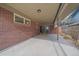 Attached carport leading to backyard area with brick wall and covered roof at 6630 E Virginia Ave, Denver, CO 80224