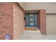 Close-up of the home's entrance, showcasing a blue front door and brick details at 6630 E Virginia Ave, Denver, CO 80224