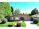 Charming single-story home with lush front yard and a brick facade and well-maintained landscaping at 6630 E Virginia Ave, Denver, CO 80224