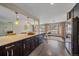 Open kitchen design with quartz countertops, dark cabinetry, and an eat-in bar overlooking the living space at 6630 E Virginia Ave, Denver, CO 80224