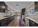 Sleek kitchen with dark wood cabinets, stainless steel appliances, and an open layout connecting to the living area at 6630 E Virginia Ave, Denver, CO 80224