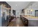 Modern kitchen featuring stainless steel appliances, dark cabinetry, and a functional layout for cooking and dining at 6630 E Virginia Ave, Denver, CO 80224